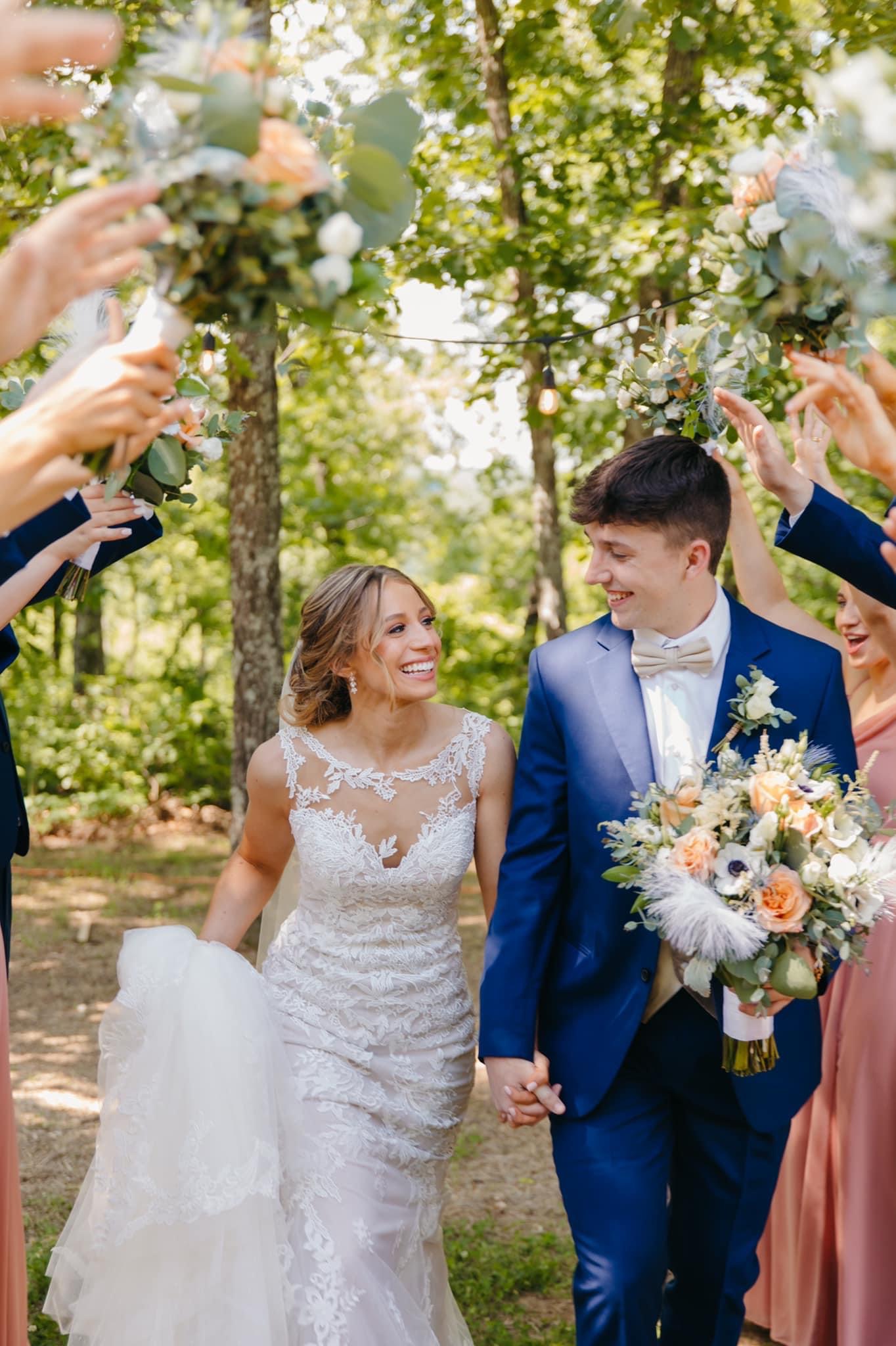 bride and groom walking by cheering wedding party